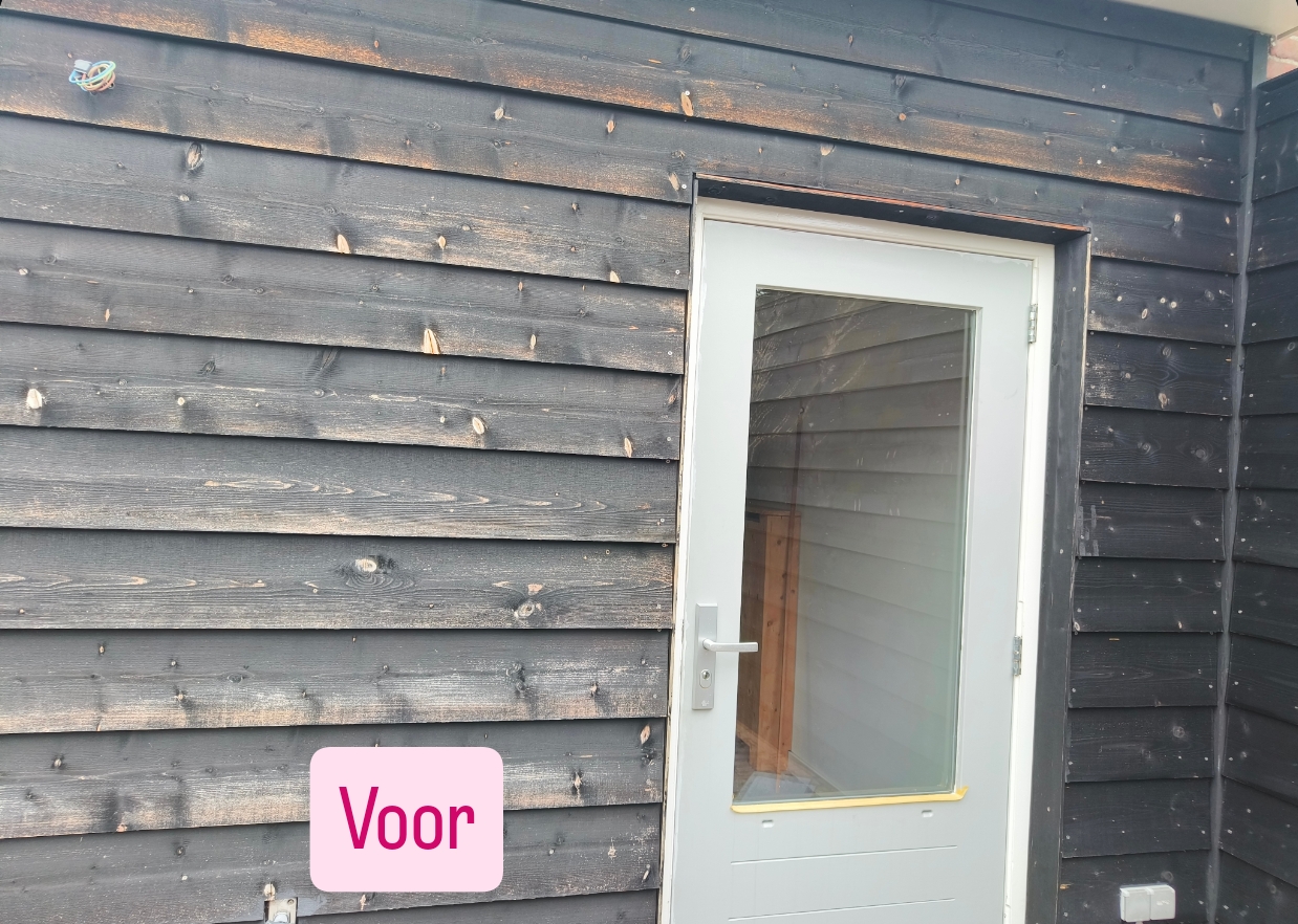 Verweerde zwarte houten gevelbekleding rondom een deur, voor behandeling